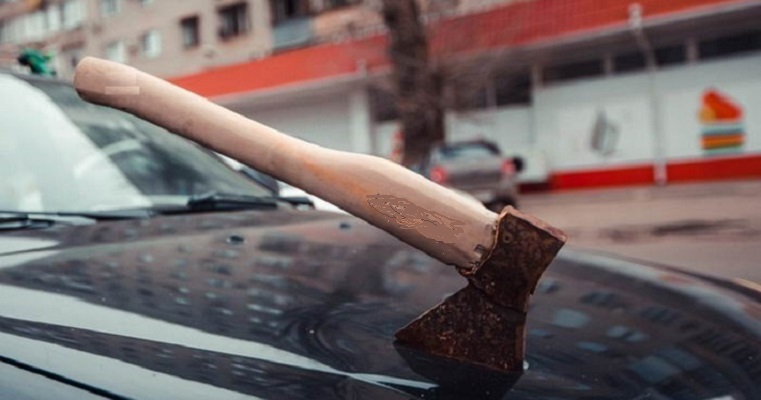 Топор в крышке капота авто